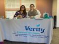 Two women from Verity sit at a presentation table during the internship fair