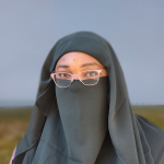 Ashley wearing pink glasses and a green niqab