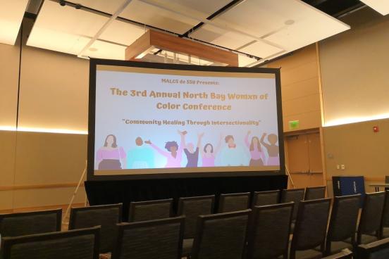 View of the projector showing art before the Womxn of Color conference started.