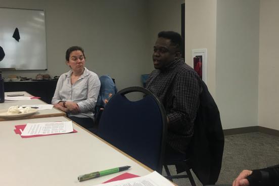 Tramaine Austin-Dillon is shown speaking about his experience teaching a service-learning course while Dr. Missy Garvin, presenter, listens. 