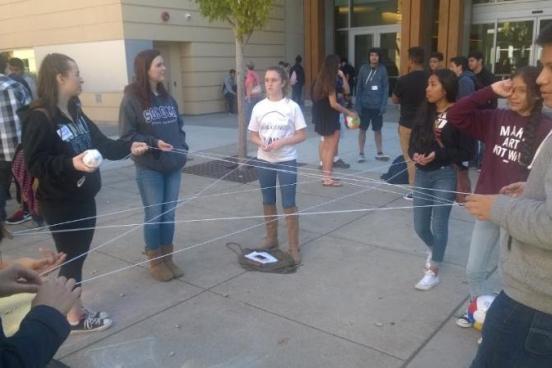 Communication students performing an ending activity with the high school students about their personal highs and lows of the day.