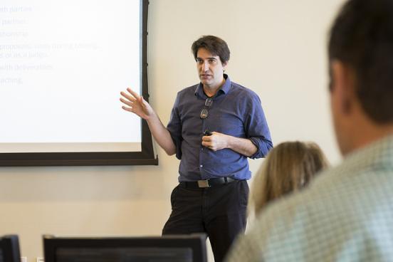 Dr. Qualls presenting in front of a projector screen