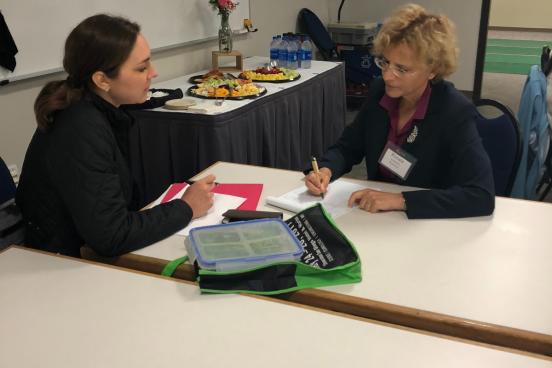 Two faculty members talking at a table