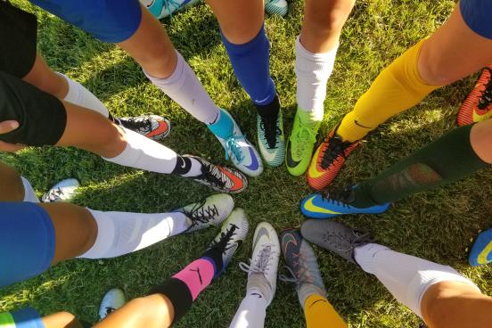 Image of legs and feet in a circle, all with athletic shoes