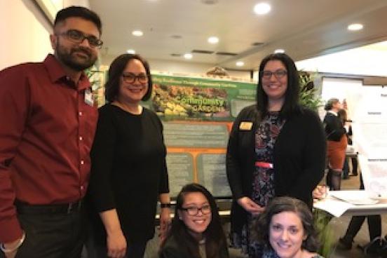 Students standing in front of presentation board