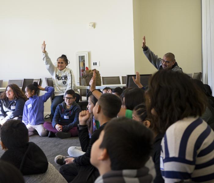 People raising hands in a group