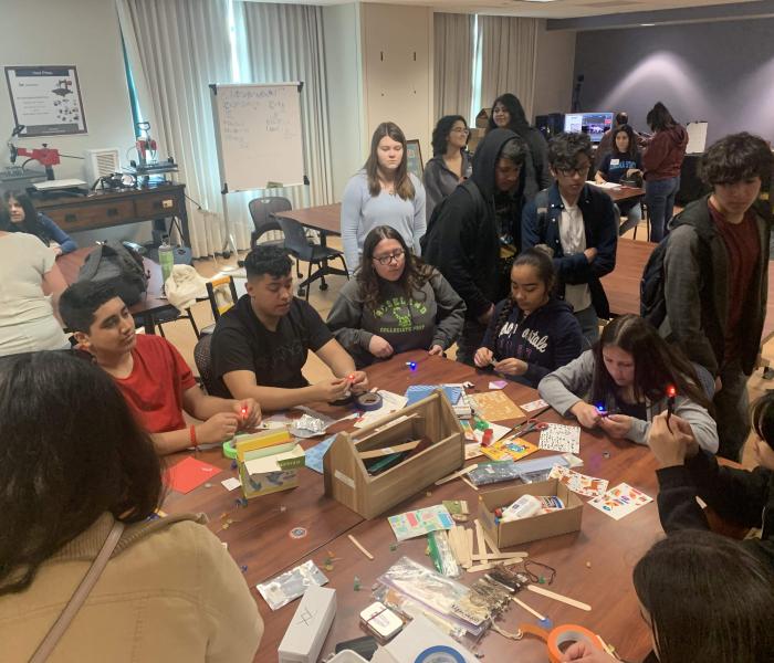Students at table full of stickers, crafts
