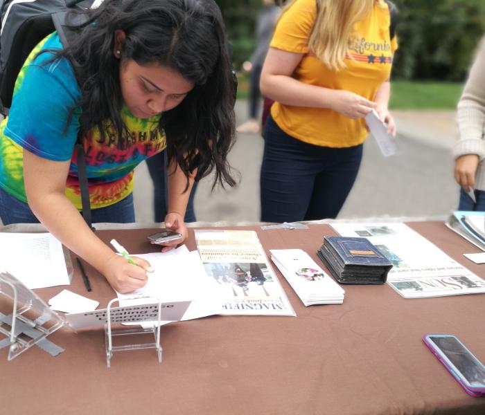 Student signing up on a community partner mailing list.