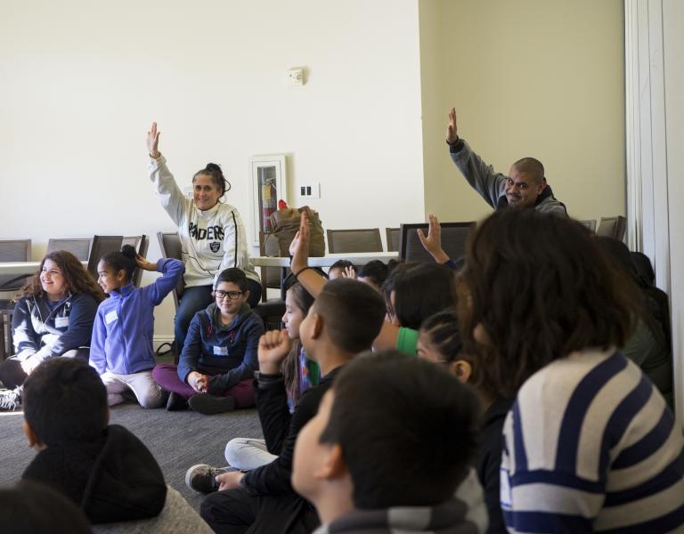 People raising hands in a group