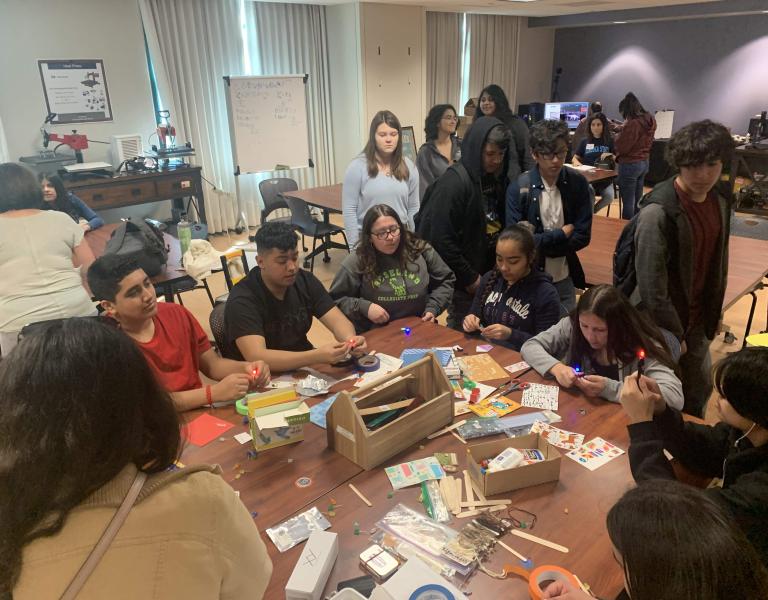 Students at table full of stickers, crafts