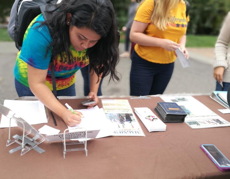 Student signing up on a community partner mailing list.