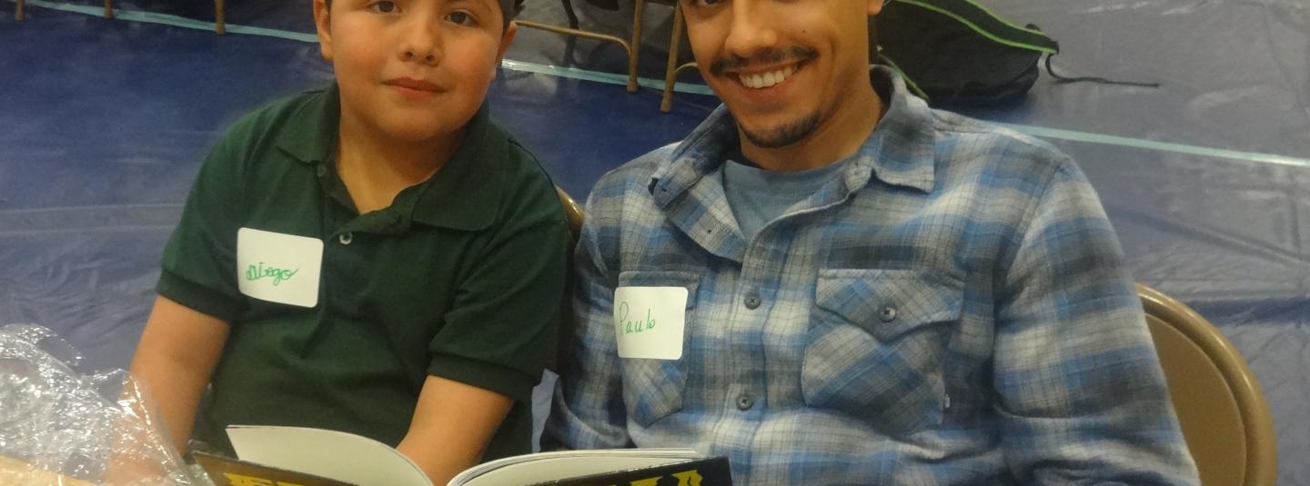 Luther Burbank student, Diego, and their SSU student partner, Paulo, reading a book together.