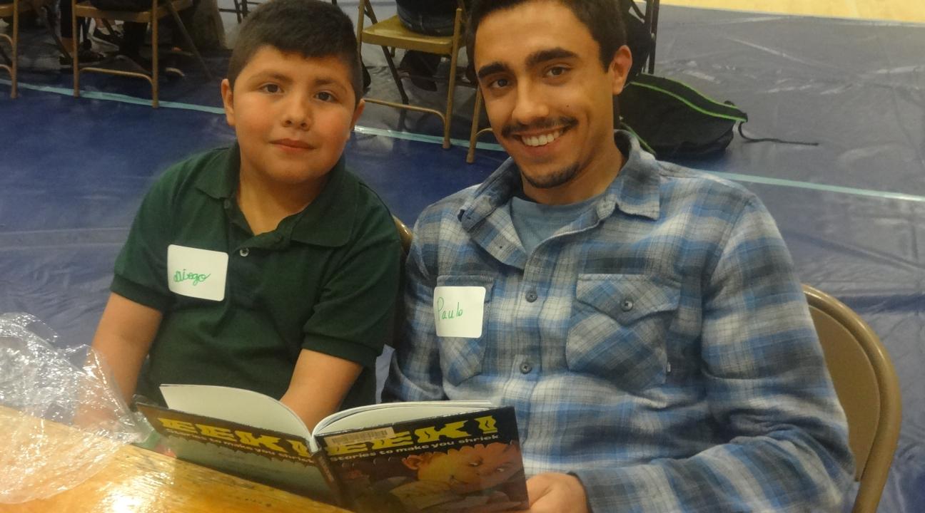Luther Burbank student, Diego, and their SSU student partner, Paulo, reading a book together.