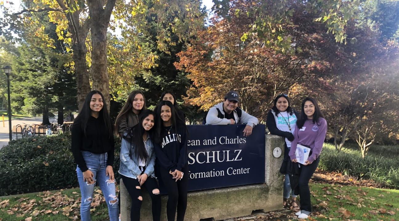 RUP Students posing in front of the Jean and Charles Schulz Information Center sign