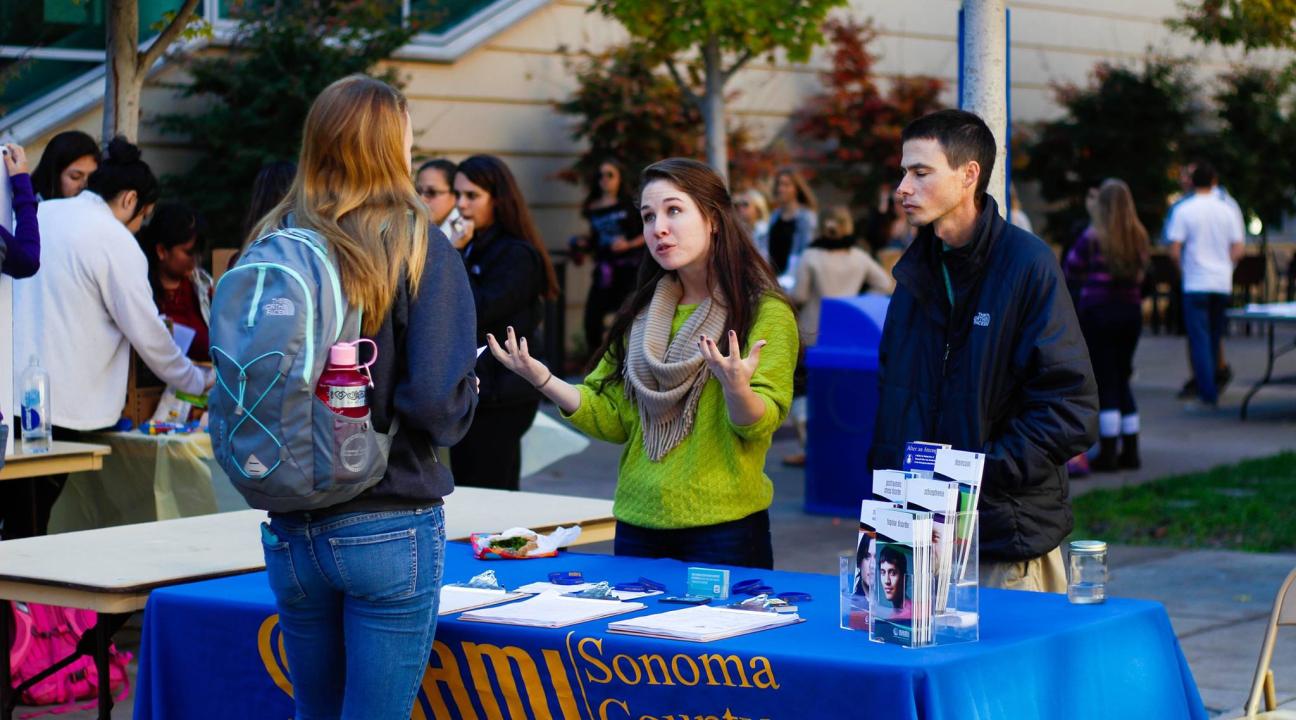 The NAMI representatives and Maddie discussing their organization during the Mental Health Promotion Fair.