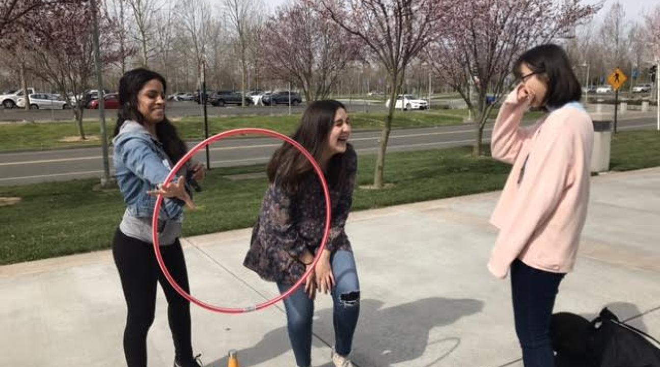 RCP and SSU students attempting to pass along a hula hoop with only their arms.
