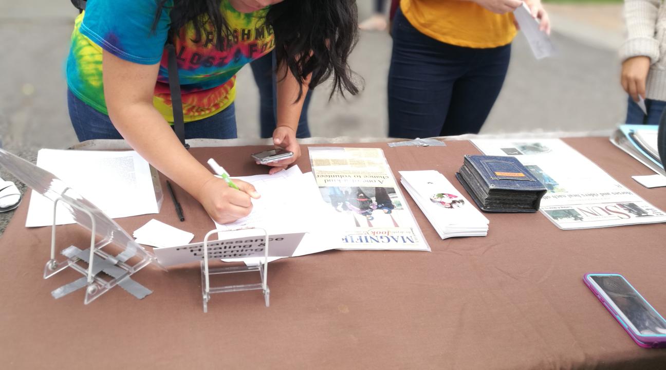 Student signing up on a community partner mailing list.