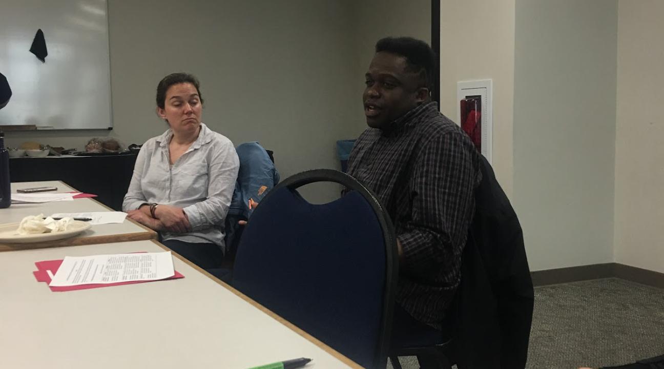 Tramaine Austin-Dillon is shown speaking about his experience teaching a service-learning course while Dr. Missy Garvin, presenter, listens. 