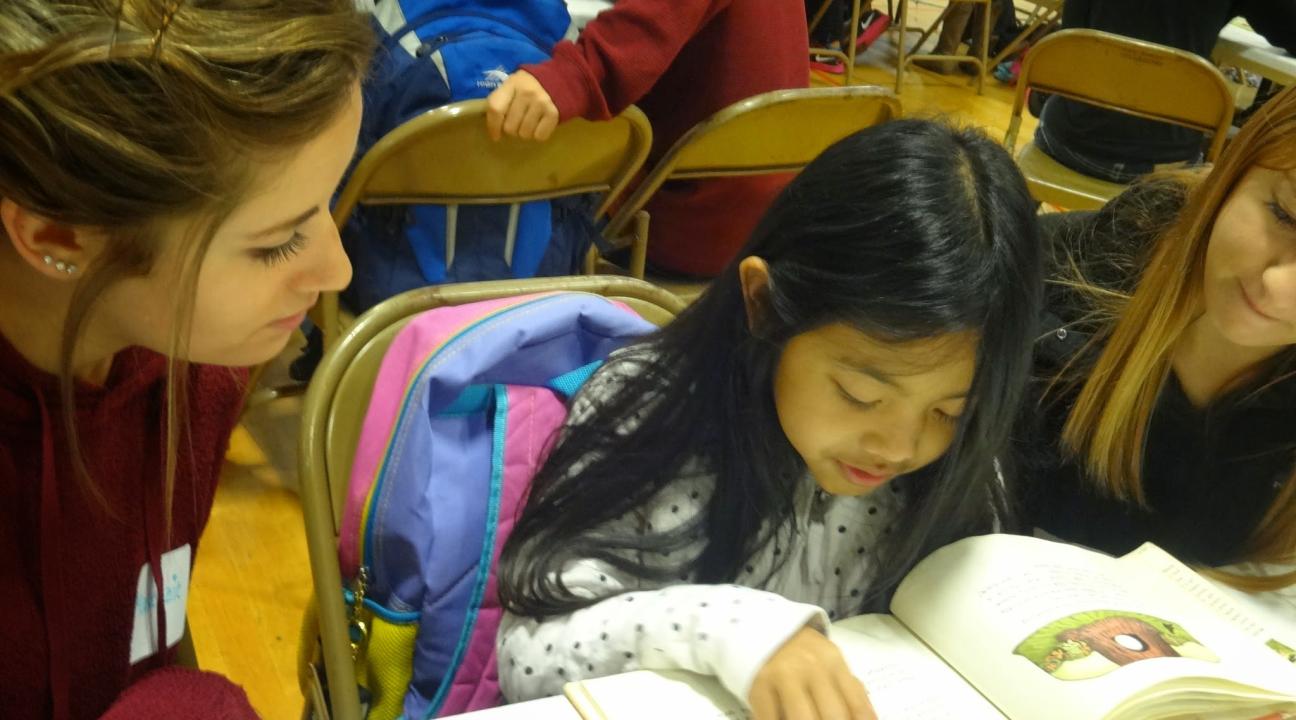 A Luther Burbank Elementary School student reading a book to an SSU service-learner at Book Buddies