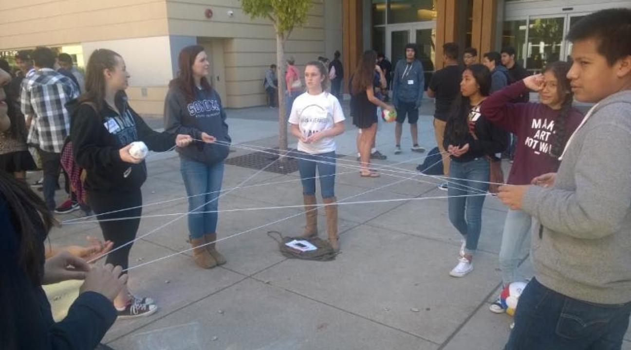 Communication students performing an ending activity with the high school students about their personal highs and lows of the day.
