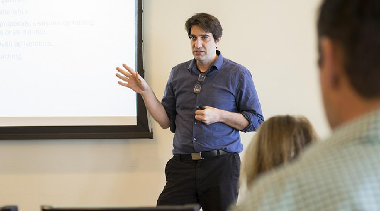 Dr. Qualls presenting in front of a projector screen
