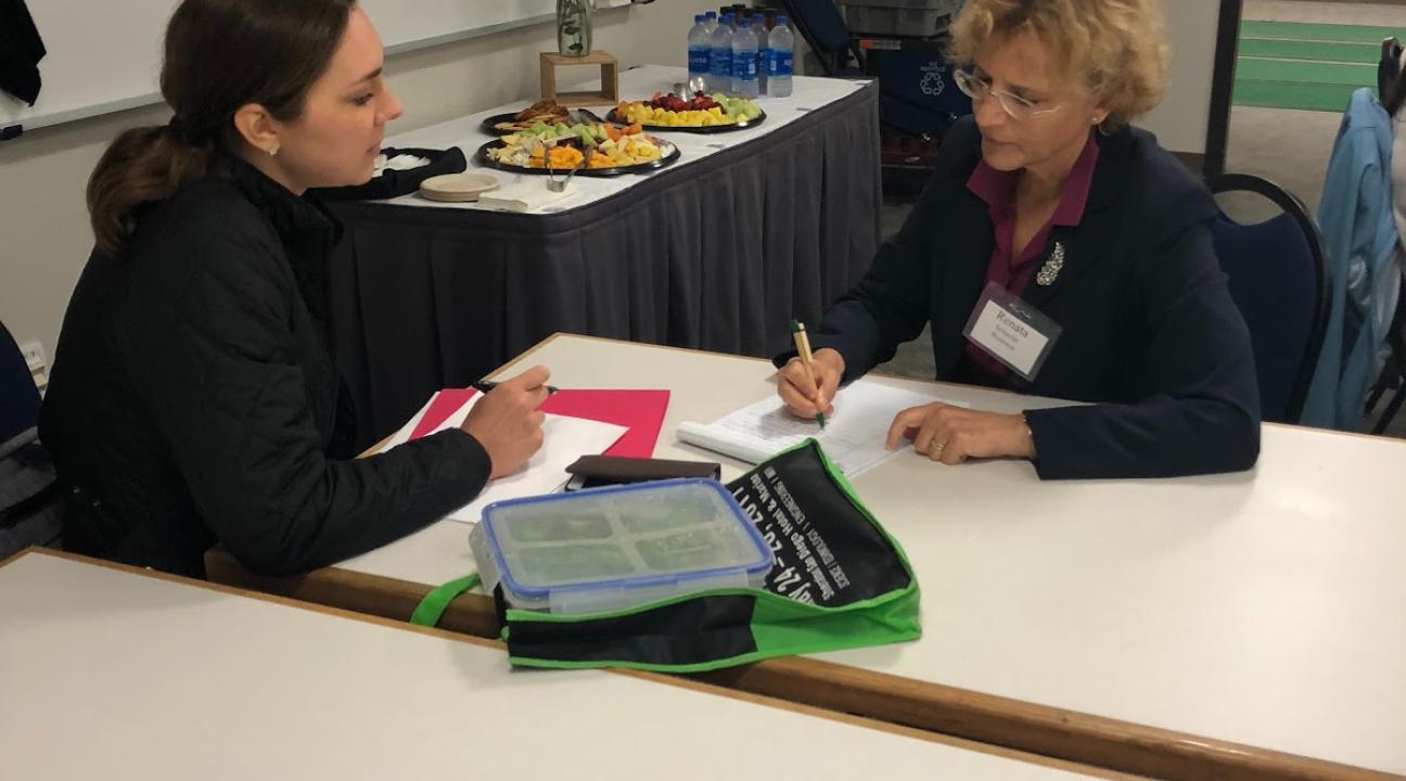 Two faculty members talking at a table