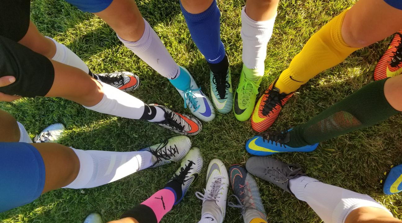 Image of legs and feet in a circle, all with athletic shoes