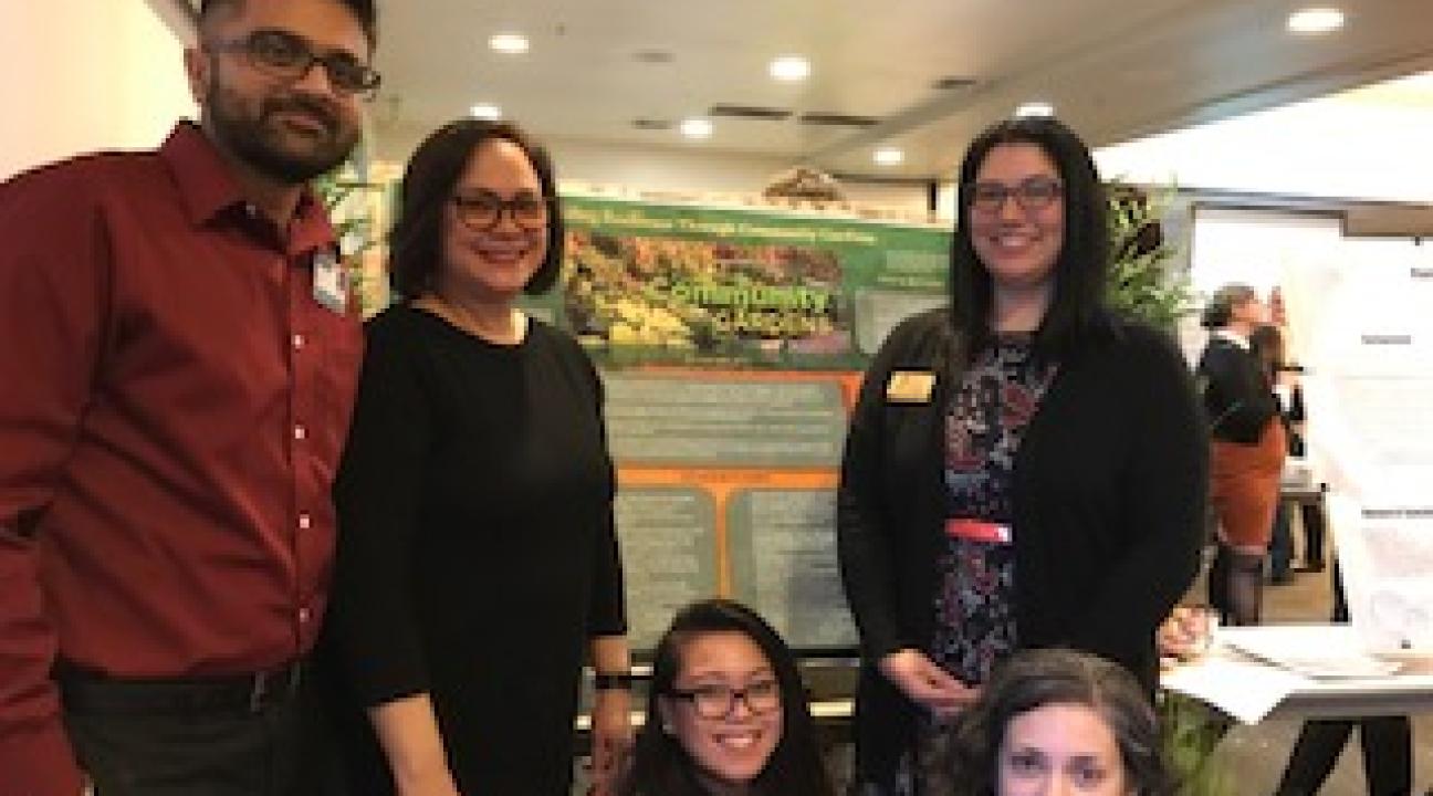 Students standing in front of presentation board