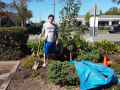 A Student standing with a shovel in a garden