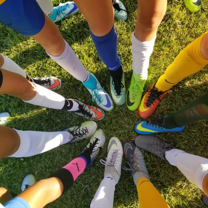 Image of legs and feet in a circle, all with athletic shoes