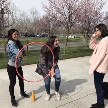 RCP and SSU students attempting to pass along a hula hoop with only their arms.