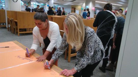 Stacey Pelton and Carolyn Smith signing the CCE's birthday card.