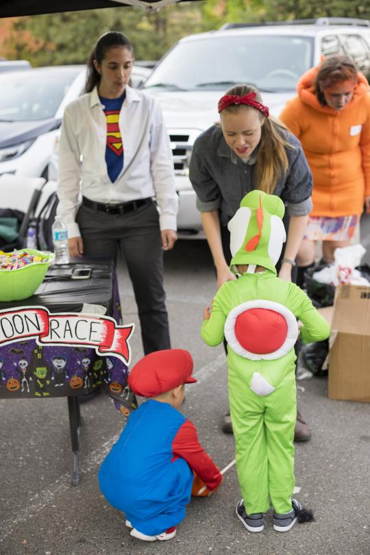 Maddie greets a child wearing a yoshi costume