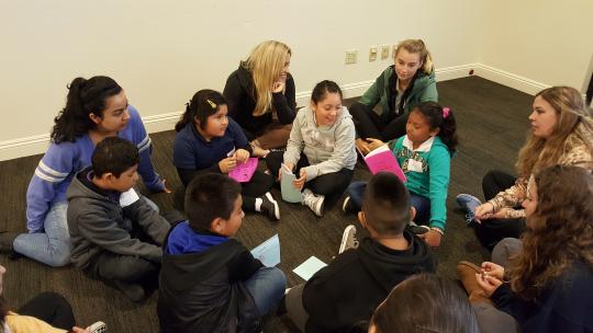 Young students sit together and share stories.