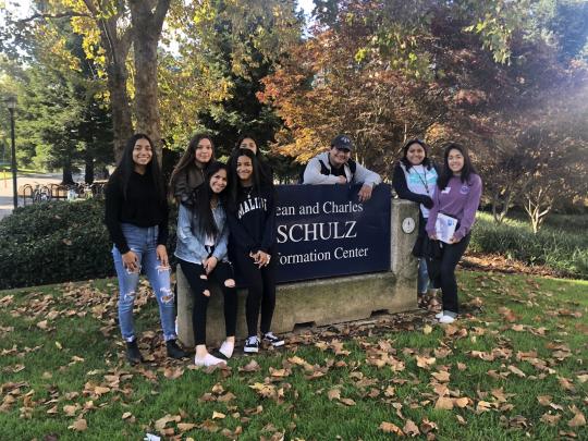 RUP Students posing in front of the Jean and Charles Schulz Information Center sign