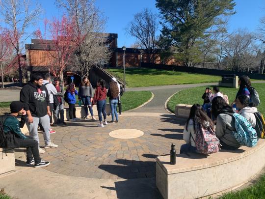 The students are seen enjoying the nice weather, talking about their experience so far at Discovery Day. 