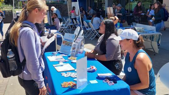 Student interacting with tabling crew at Service & Internship Fair