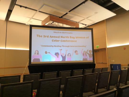 View of the projector showing art before the Womxn of Color conference started.