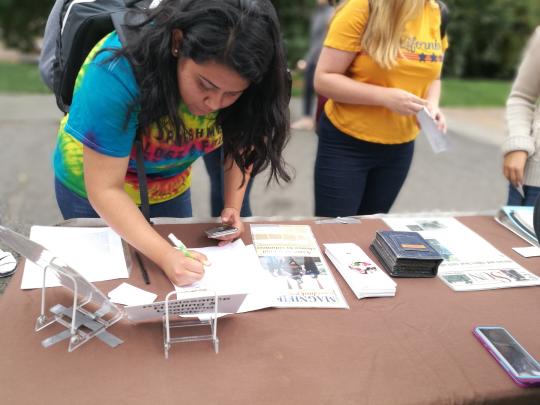 Student signing up on a community partner mailing list.