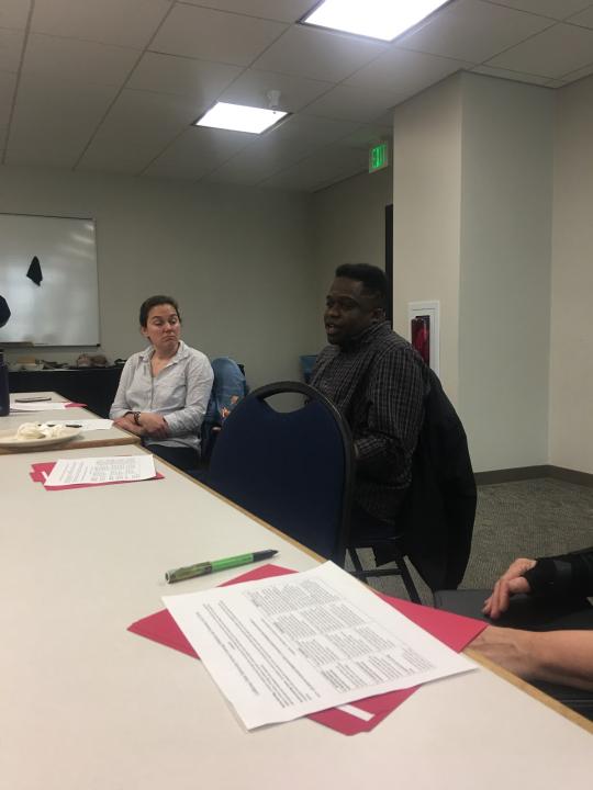 Tramaine Austin-Dillon is shown speaking about his experience teaching a service-learning course while Dr. Missy Garvin, presenter, listens. 