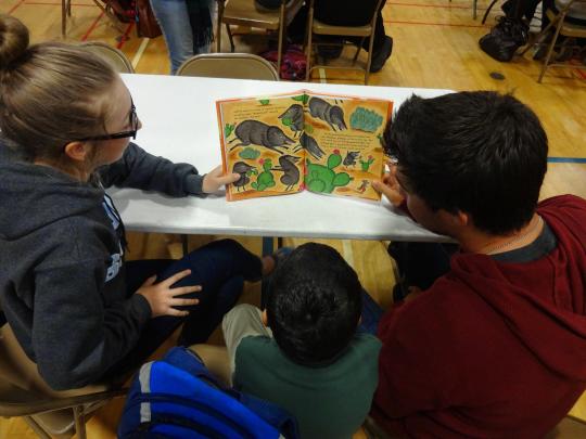 Two SSU students and a Luther Burbank student enjoy a book together.