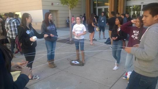 Communication students performing an ending activity with the high school students about their personal highs and lows of the day.