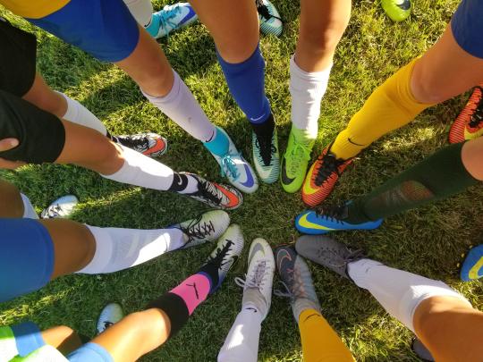 Image of legs and feet in a circle, all with athletic shoes