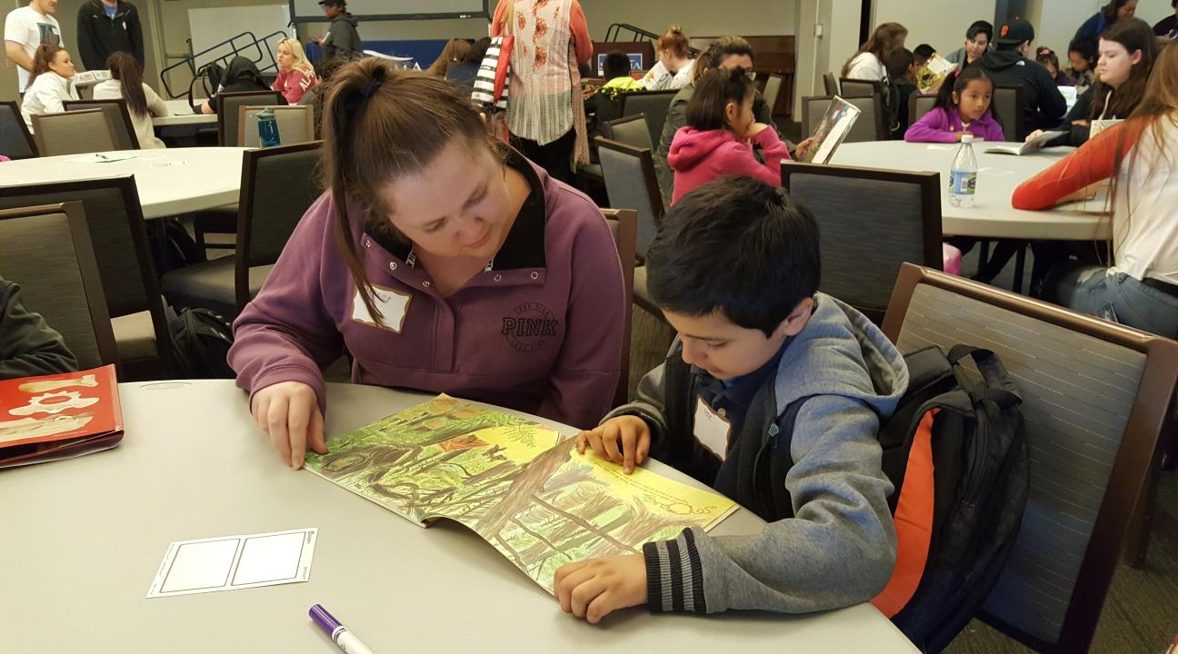 Meadow View student reading to a Sonoma State service-learner.
