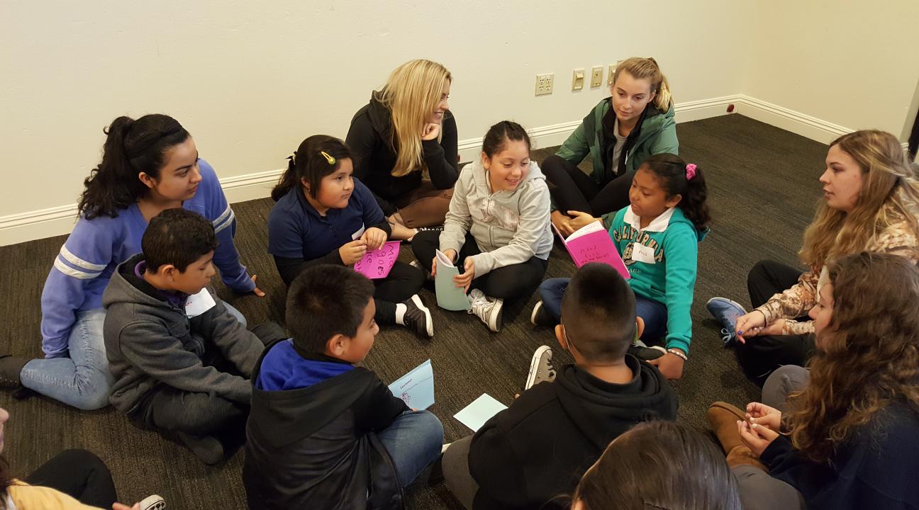 Young students sit together and share stories.