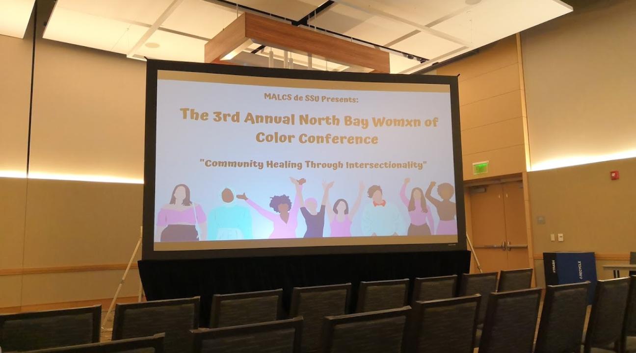 View of the projector showing art before the Womxn of Color conference started.